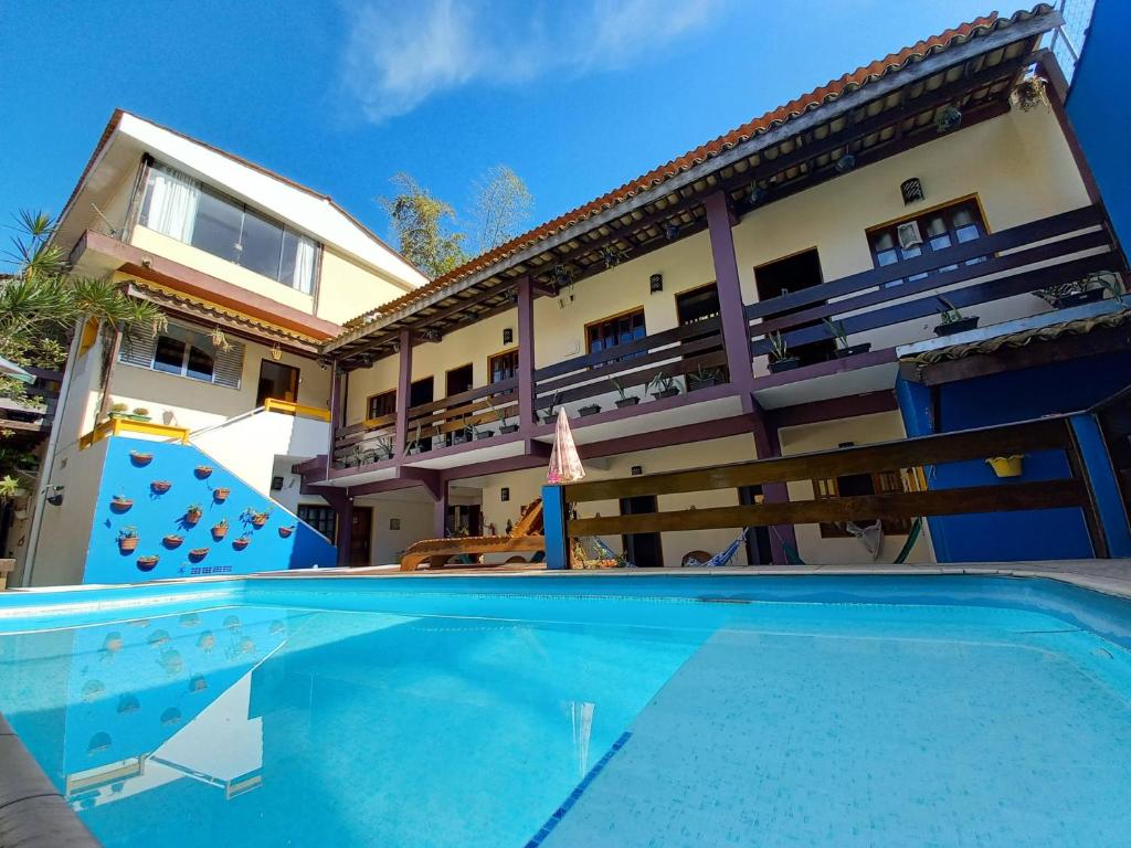 ein Haus mit einem Pool vor einem Gebäude in der Unterkunft Pousada Santé in Guarujá