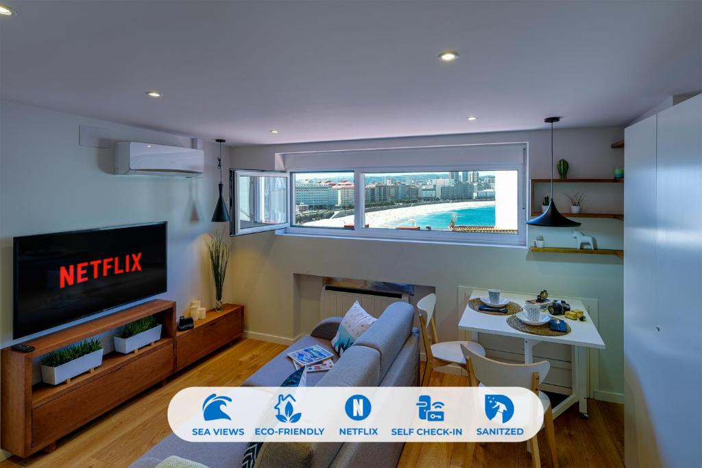 uma sala de estar com um sofá e uma televisão em Orzan Beach 1 by TheBlueWaveApartments com em La Coruña