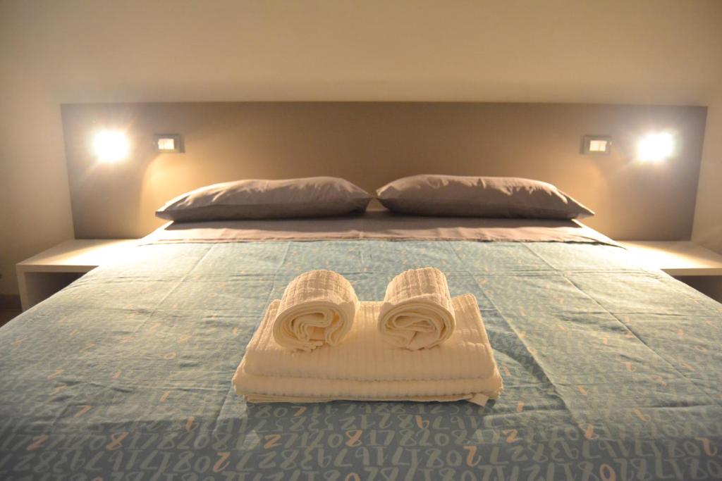 a bed with a pair of shoes on top of it at Il Birillo Casa Vacanze in Trapani