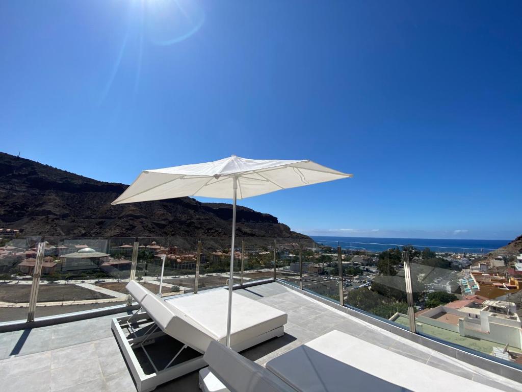 an umbrella on the roof of a house at Billy's Marina 360 with pool access in Puerto de Mogán