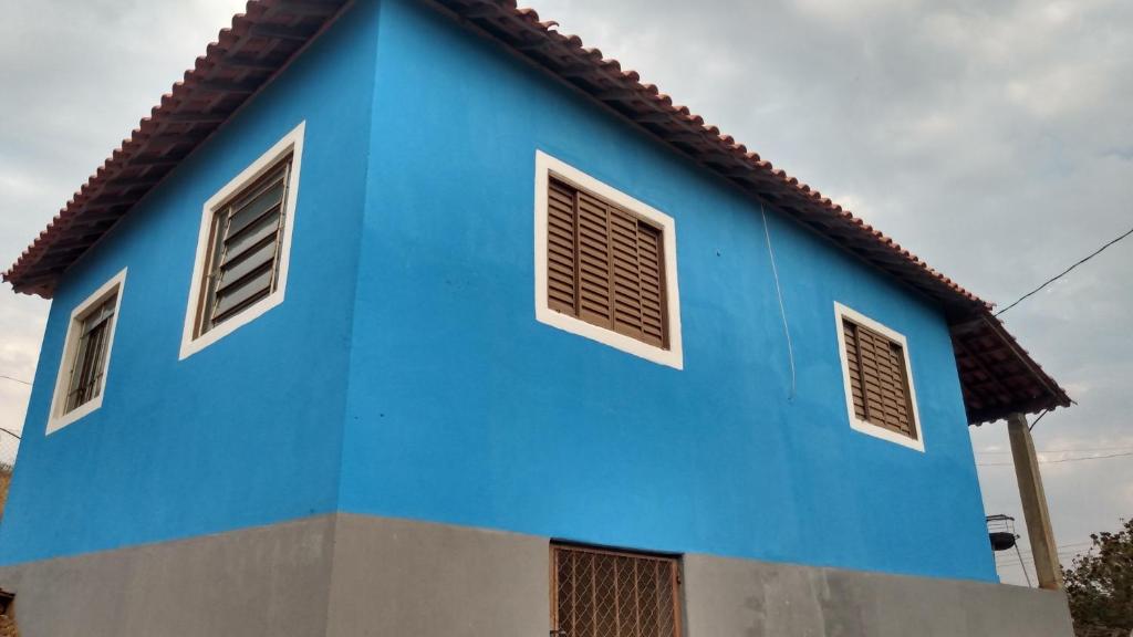 ein blaues Gebäude mit drei Fenstern darüber in der Unterkunft Casa Nascer do Sol in São Thomé das Letras
