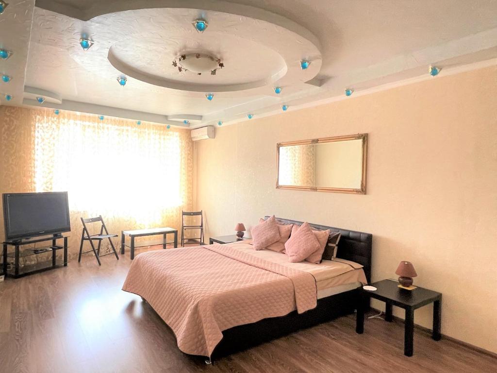 um quarto com uma cama e uma televisão de ecrã plano em LuxCityApart on Olievskaya em Kiev