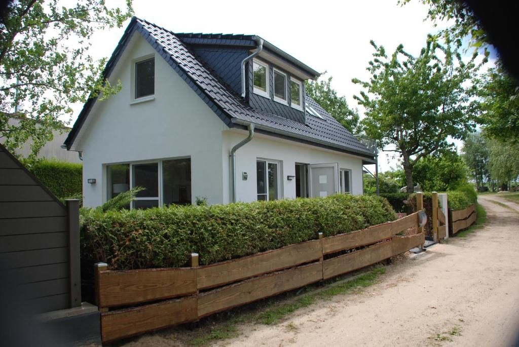 uma casa branca com uma cerca de madeira em frente em Ferienhaus Sonnenschein em Insel Poel