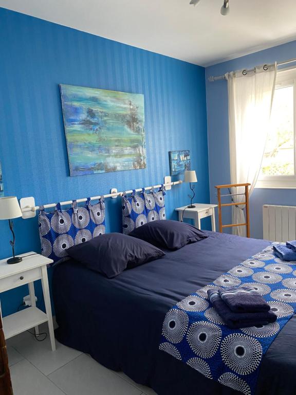 Le Home VaravilleにあるBelle villa la galinocheの青い壁のベッドルーム1室(ベッド1台付)