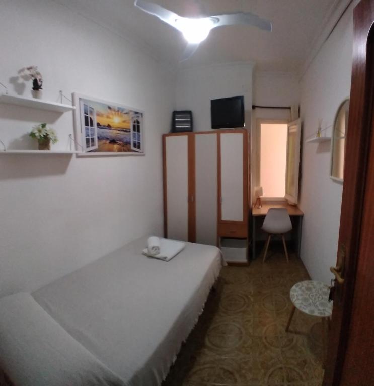 Habitación pequeña con cama y escritorio. en Cozy single room Mercado Central, en Alicante