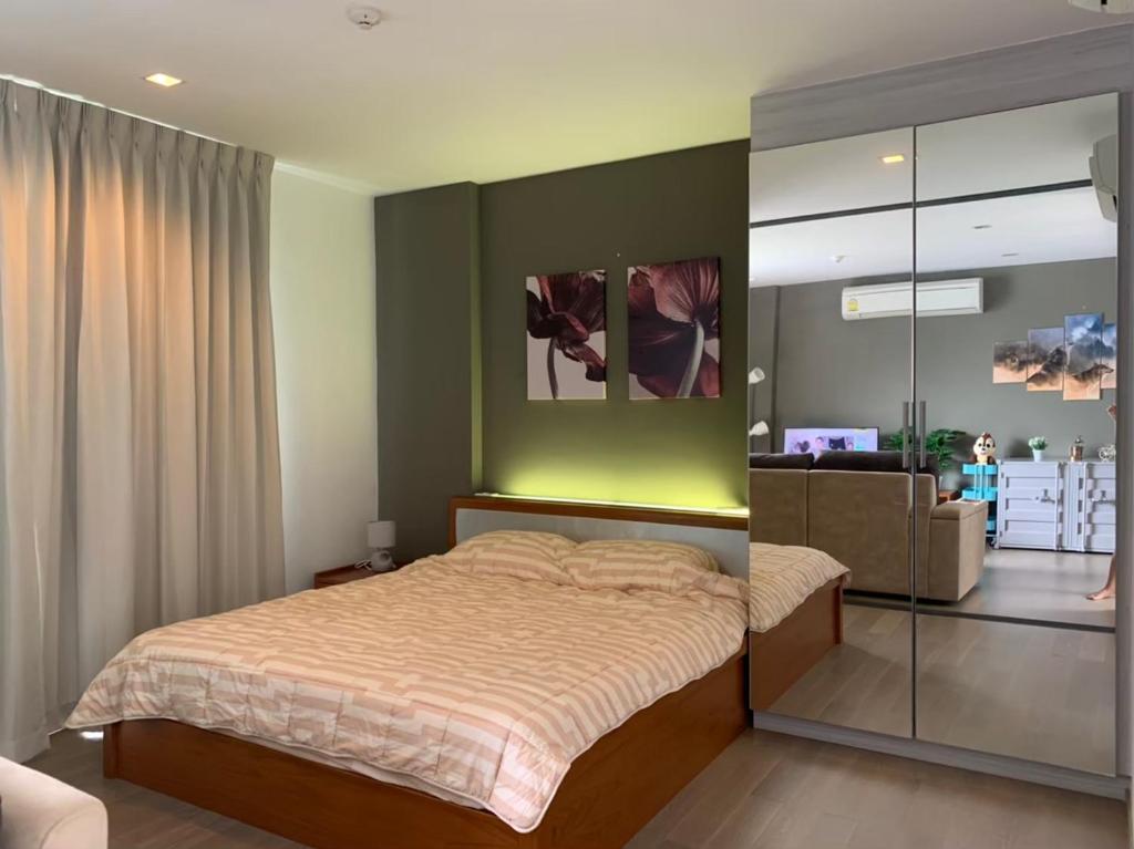 a bedroom with a bed with a green wall at The Valley Khao Yai in Ban Huai Sok Noi
