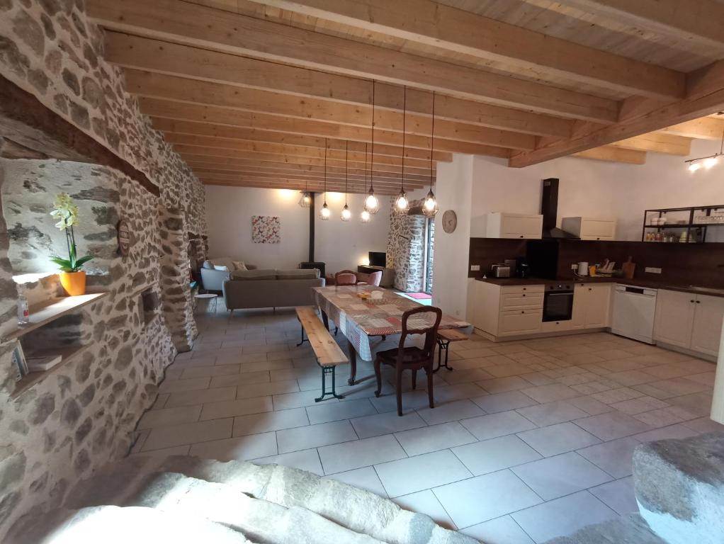 a kitchen and living room with a table and chairs at gîte de groupe L'Estable in Saint-Cirgues