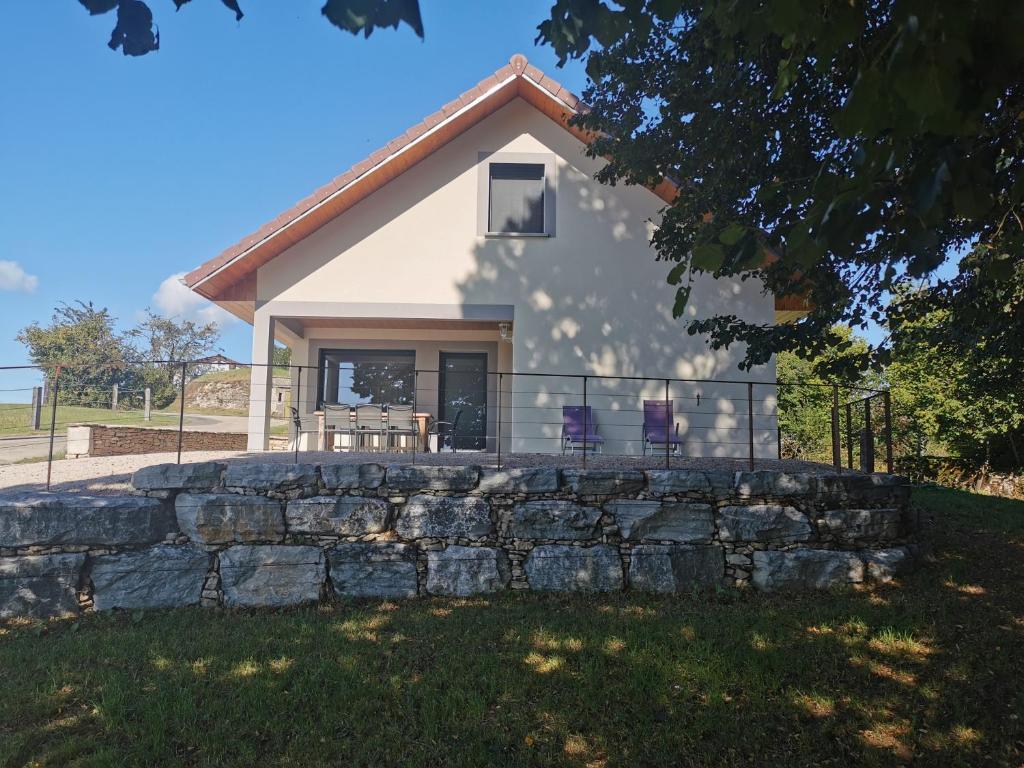 una casa con una pared de piedra delante de ella en La Maison du Colombier en Le Fied