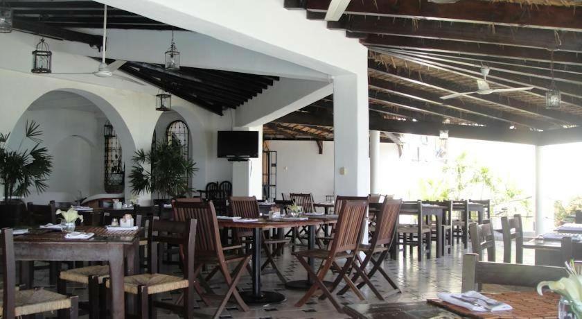 una sala da pranzo con tavoli, sedie e TV di Depa Teques a Tequesquitengo
