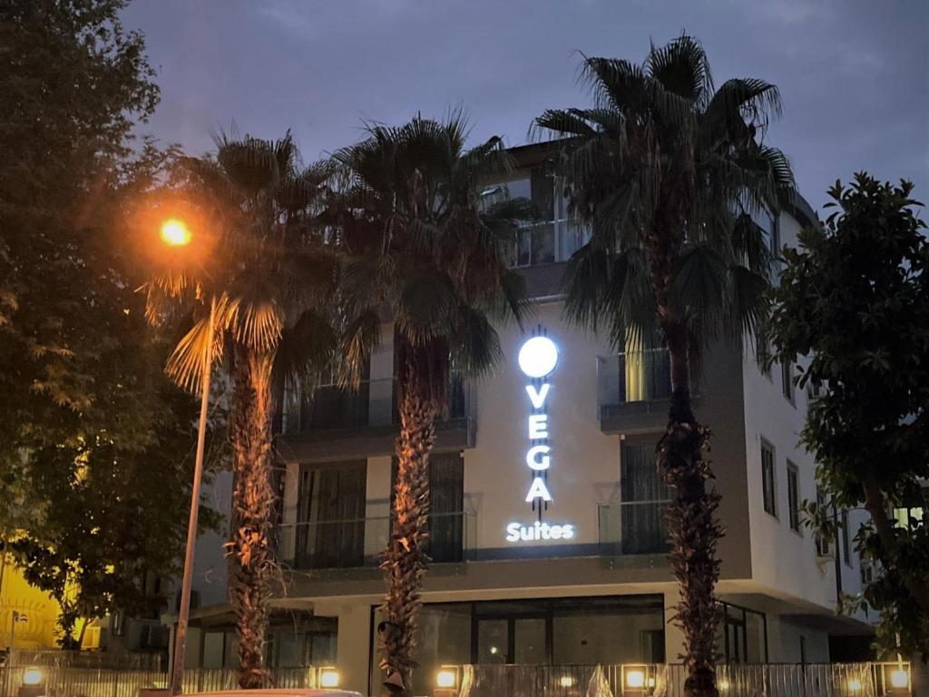 a hotel with palm trees in front of it at Vega Suites in Antalya