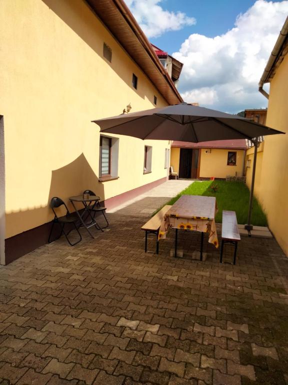 a patio with an umbrella and a table and chairs at Mario's Cozy Apartment in Râşnov