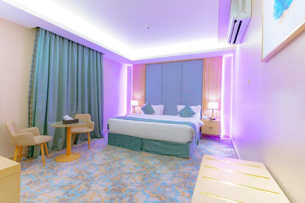 a hotel room with a bed and a table and chairs at ريـزورد بـلازا - RIZORD plaza in Hafr Al-Batin