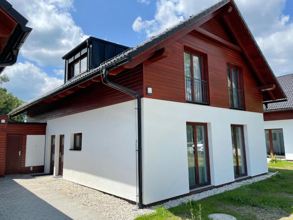 una casa roja y blanca con garaje en Apartmán D5 Nová Pec, en Nová Pec