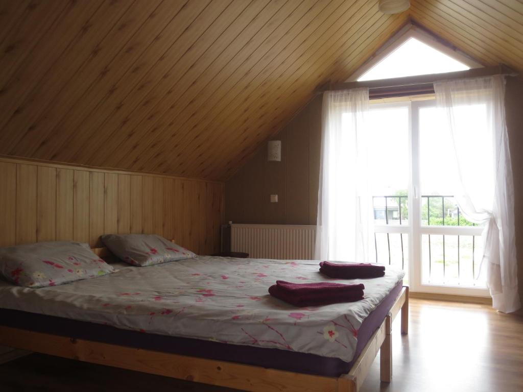 a bedroom with a bed and a large window at Jūras sāga in Pāvilosta