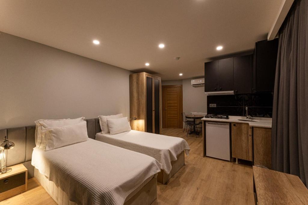 a hotel room with two beds and a kitchen at Long Stay İstanbul Residence in Istanbul