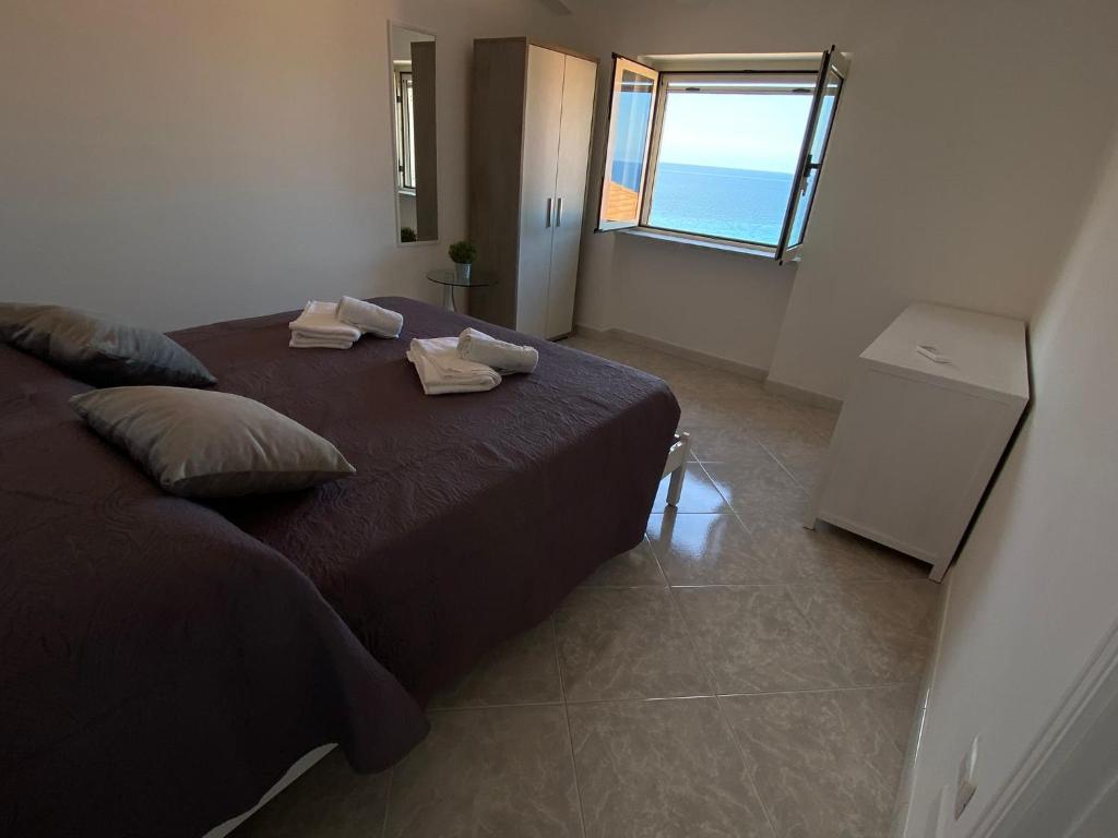 een slaapkamer met een groot bed en uitzicht op de oceaan bij Petra Marina Aurora in Pisciotta