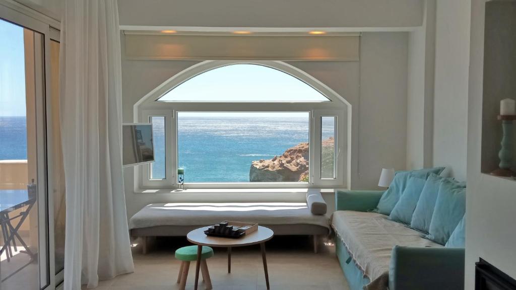 uma sala de estar com um sofá e uma grande janela em ISALO Villa em Makry Gialos