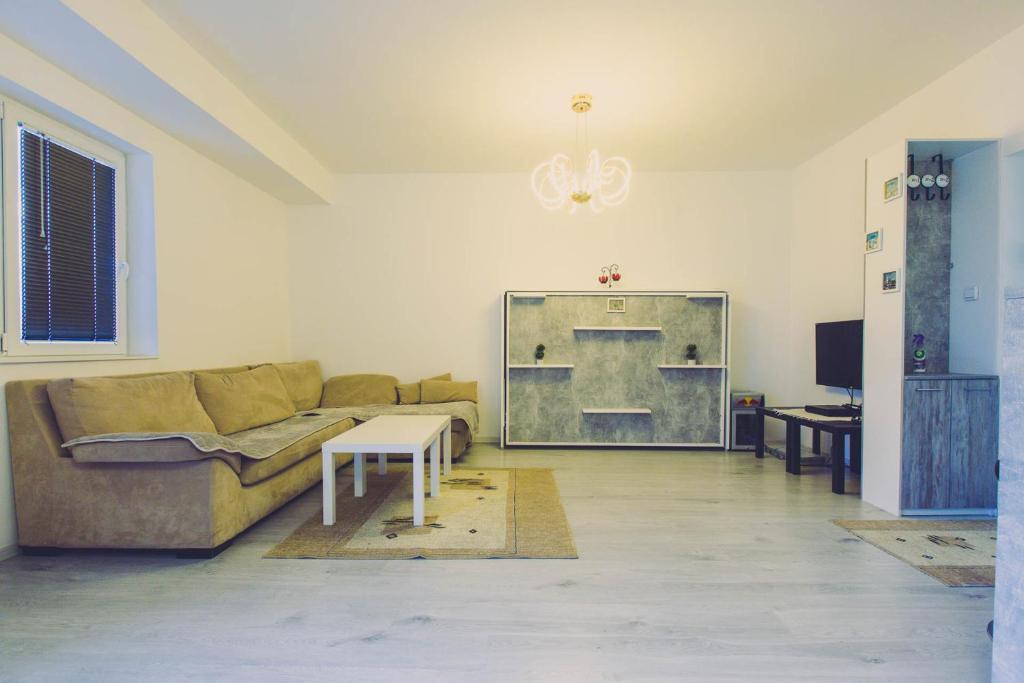 een woonkamer met een bank en een tafel bij Hristovi apartments in Skopje