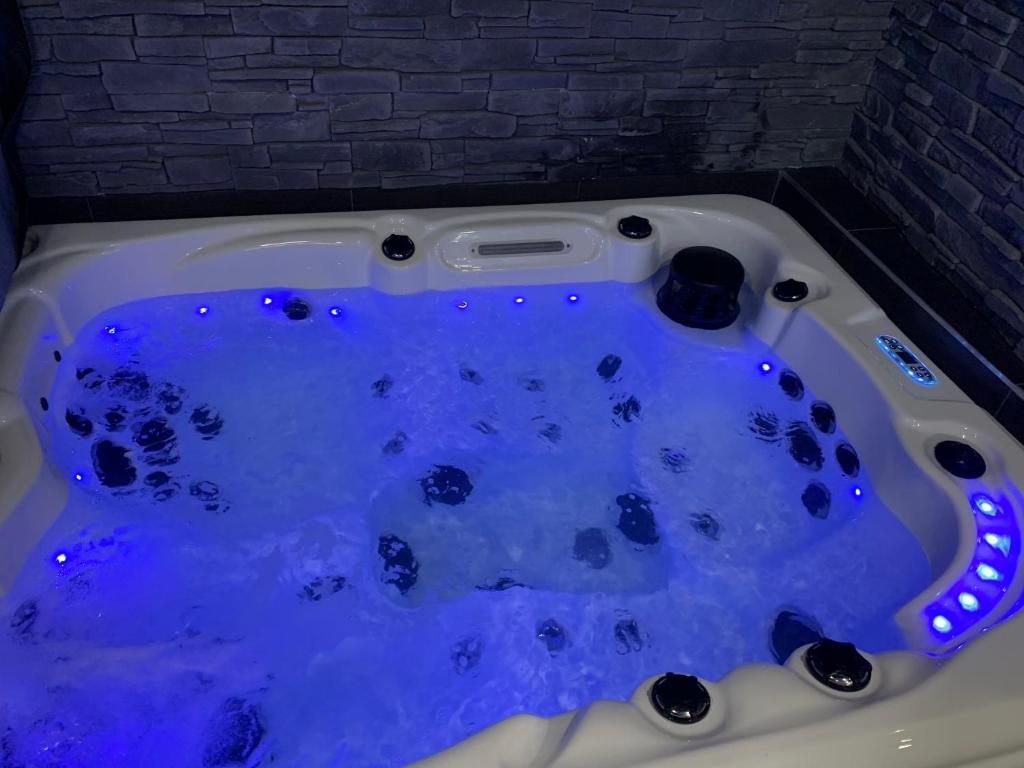une baignoire jacuzzi avec des lumières bleues dans une chambre dans l'établissement Diane Luxury 2, à Roubaix