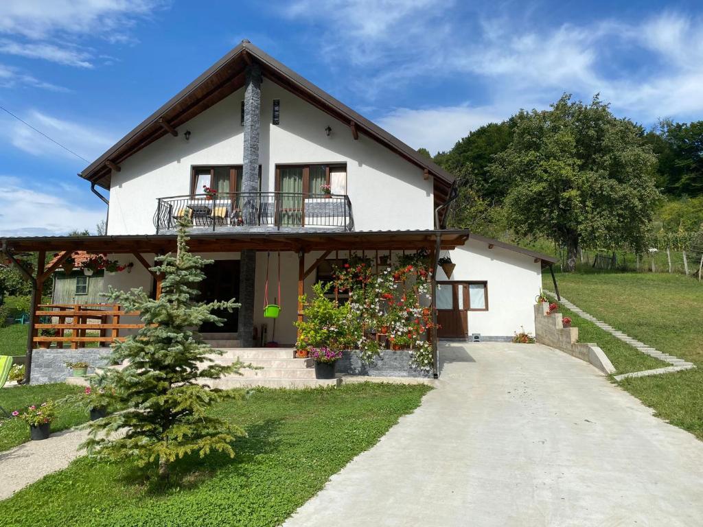 a white house with a balcony and a porch at Casa Alex in Curtea de Argeş