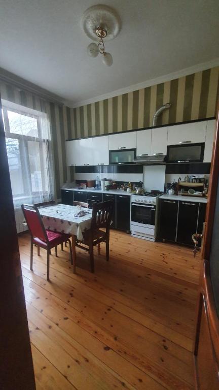 a kitchen with a table and chairs in a room at Дом в Хырдалане in Xirdalan