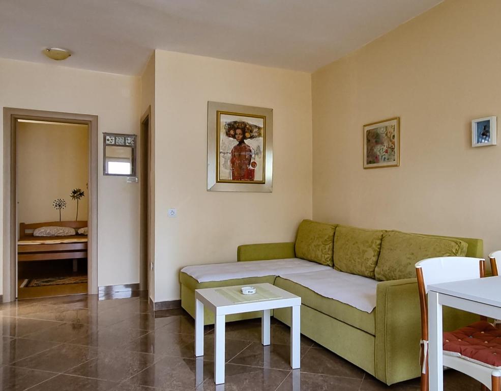 a living room with a green couch and a table at Luxury Apartment Maja in Tivat