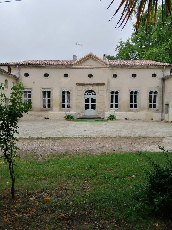 un grand bâtiment blanc avec beaucoup de fenêtres dans l'établissement Maison d'Hôtes de La Rivière, à Pexiora