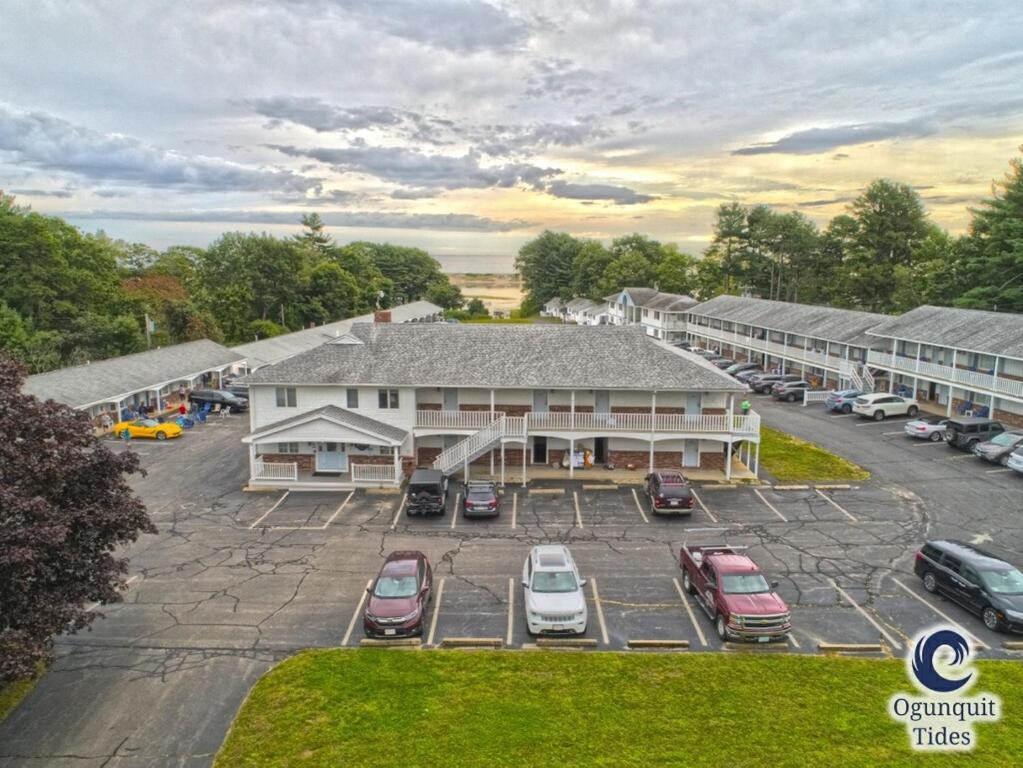 une vue aérienne d'un bâtiment avec des voitures garées sur un parking dans l'établissement Ogunquit Tides, à Ogunquit