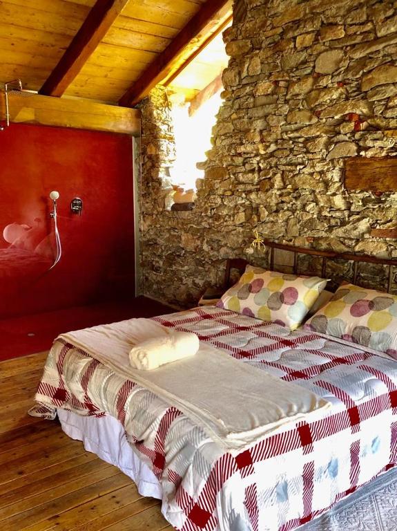 a bedroom with two beds in a stone wall at La torretta in Pessinetto
