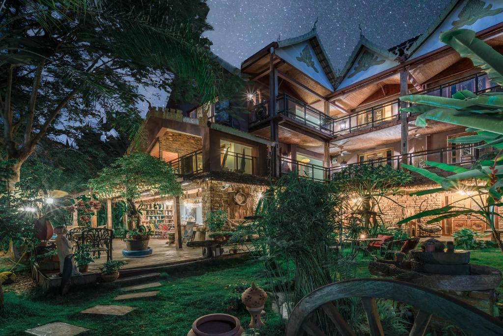 ein großes Haus mit Garten in der Nacht in der Unterkunft Hidden Garden Inn (Airport Transfer) in Jinghong