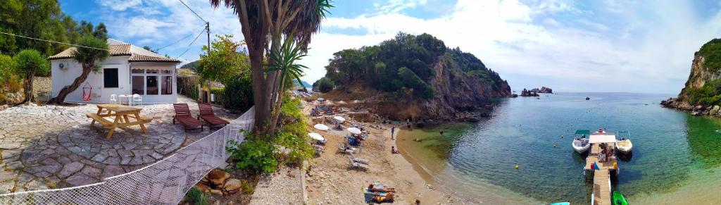 uma vista para uma praia com um barco na água em Ampelaki Blue em Paleokastritsa