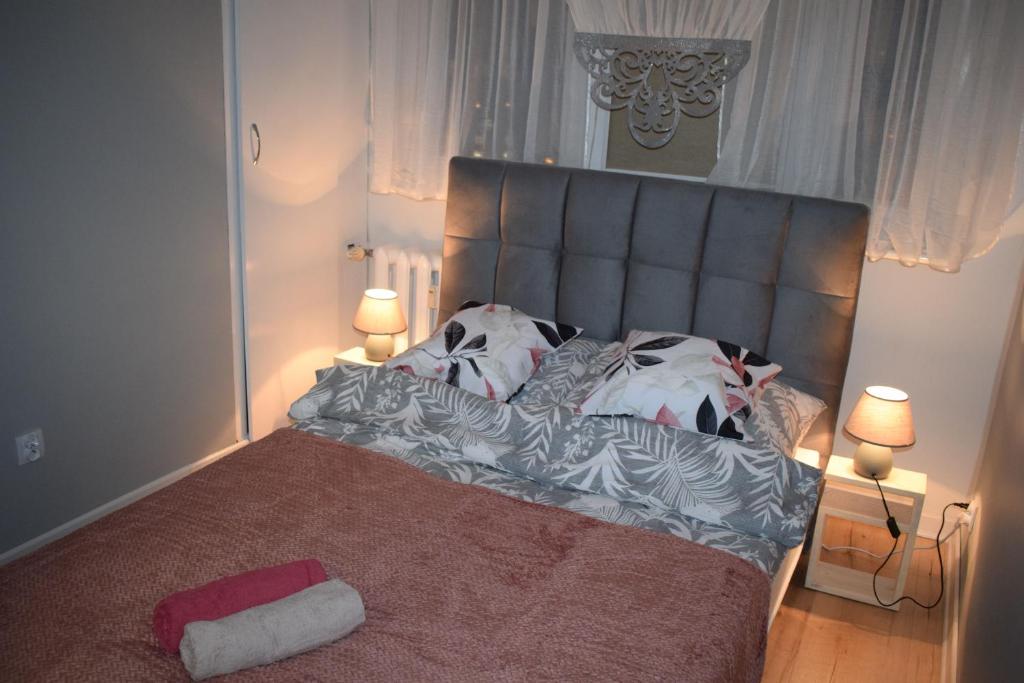 a bedroom with a large bed with two lamps at Apartament M-3 CENTRUM in Częstochowa