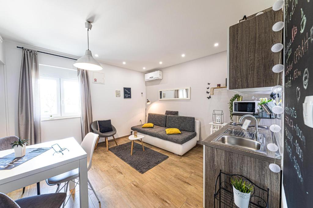 cocina y sala de estar con sofá y mesa en Apartments Trio- An amazing view of Split en Klis