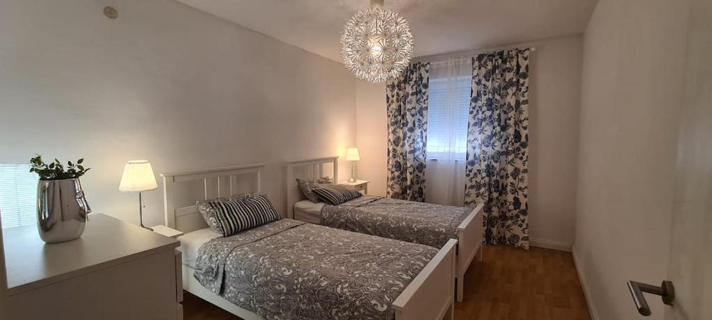 sypialnia z 2 łóżkami i żyrandolem w obiekcie La Pergola w Fažanie