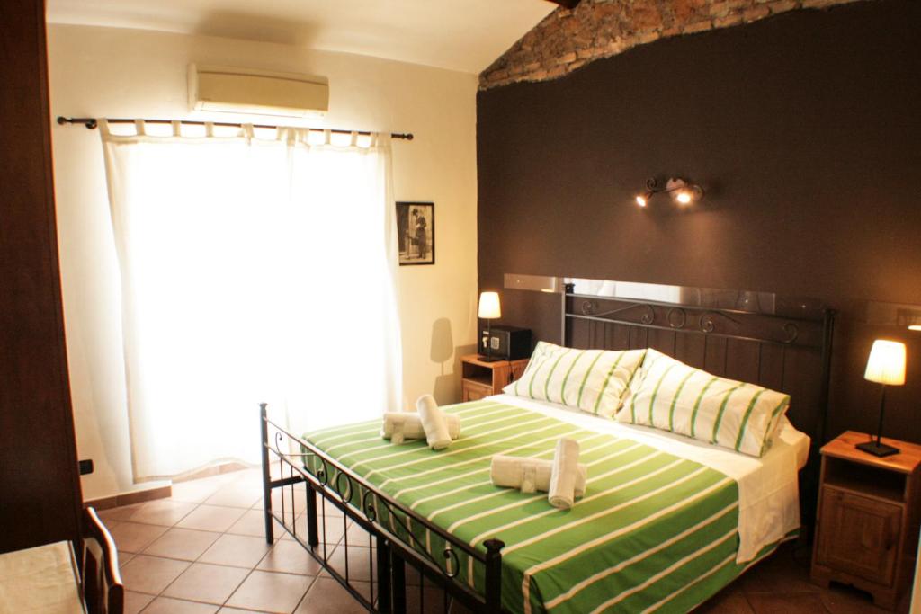 a bedroom with a bed with a green and white blanket at Sixtythree guesthouse in Rome