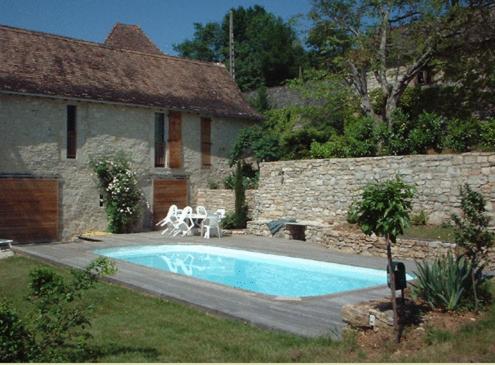 - une piscine dans une cour à côté d'une maison dans l'établissement Les Maisons de Marie, à Cajarc