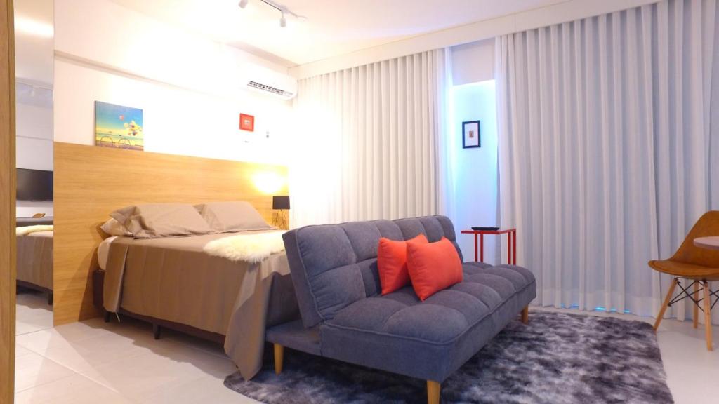a bedroom with a bed and a blue chair at Studio 818 no edf. TIME, Ponta Verde in Maceió