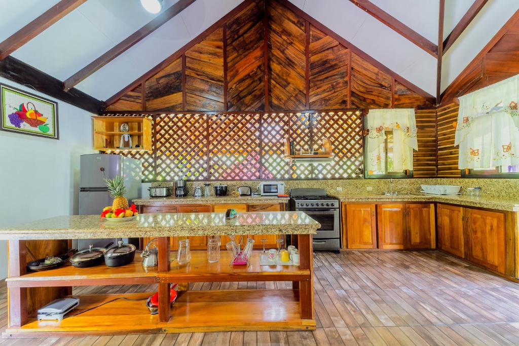 a large kitchen with wooden floors and wooden cabinets at Casa Shaquir H - Coastal Bliss Oasis in Puerto Viejo