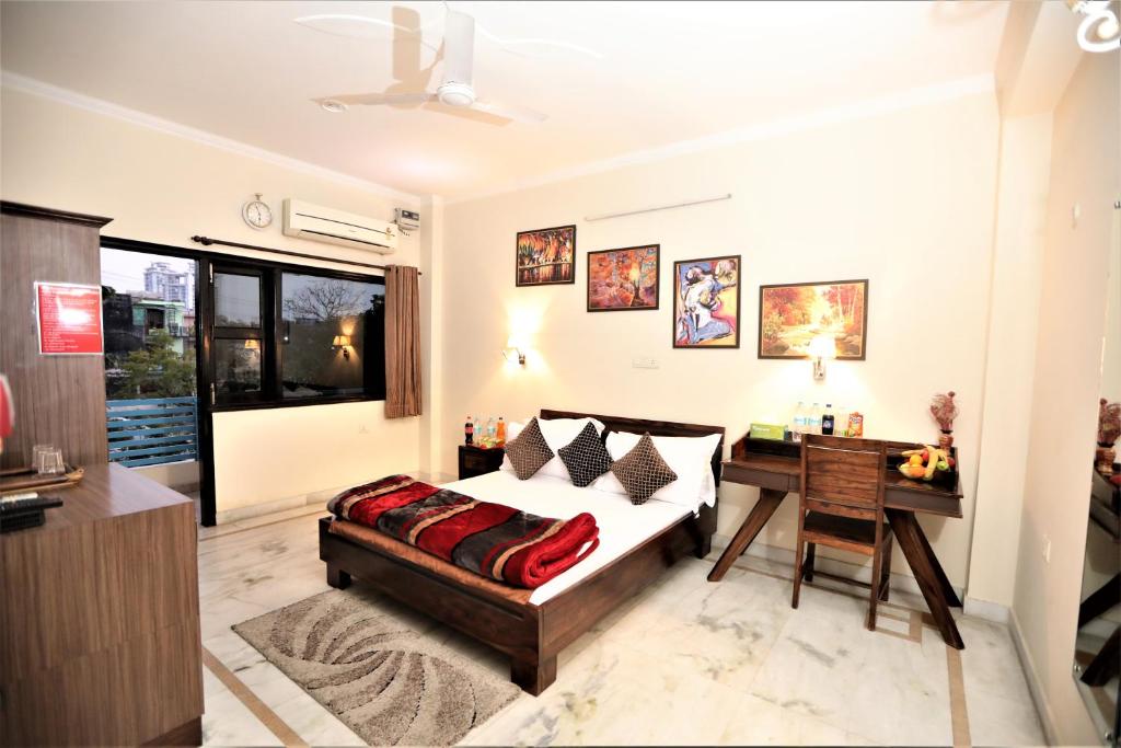 a bedroom with a bed and a table and a desk at Bhambri Expo House in Greater Noida
