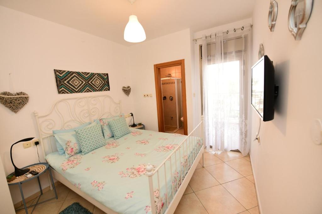 1 dormitorio con 1 cama y TV en shohamseaview, en Eilat