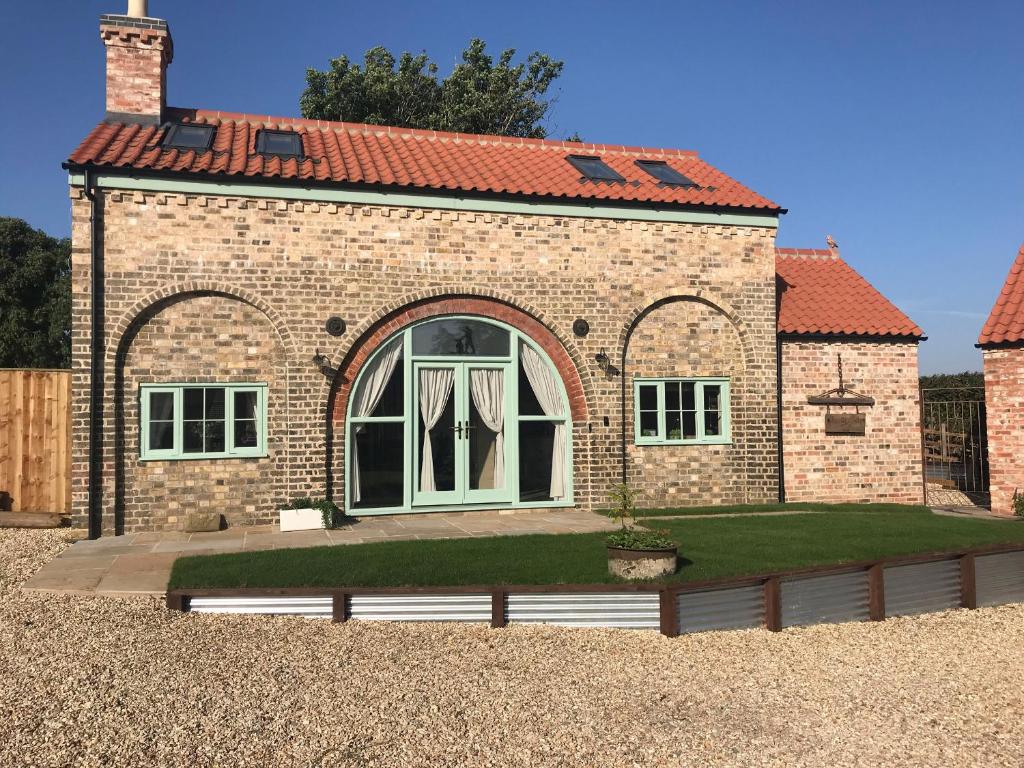 a brick house with a lawn in front of it at The Old Smithy in Horncastle