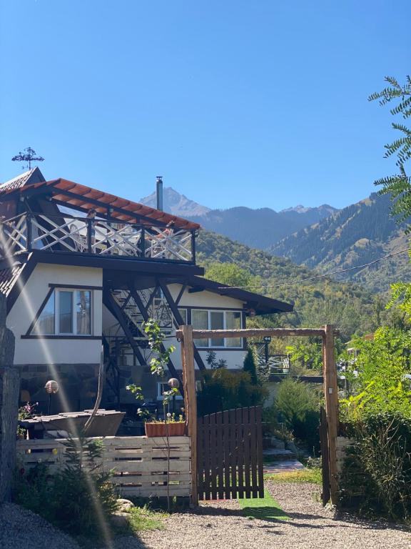 uma casa com uma cerca de madeira em frente em Dobri Dom em Almaty