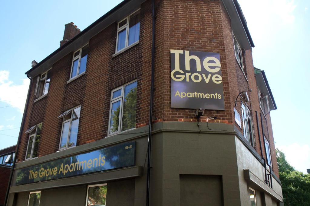 un edificio de ladrillo con un cartel que lee los apartamentos Grove en Grove Apartments en Londres
