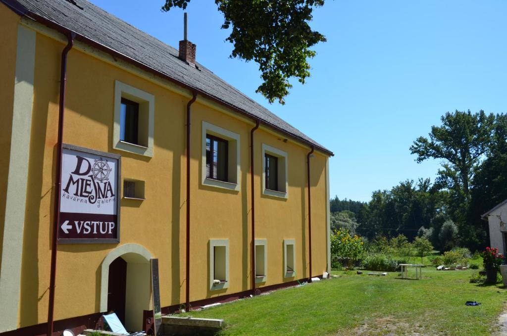 ein gelbes Gebäude mit einem Schild an der Seite in der Unterkunft Apartmán Nad potokem in Český Rudolec