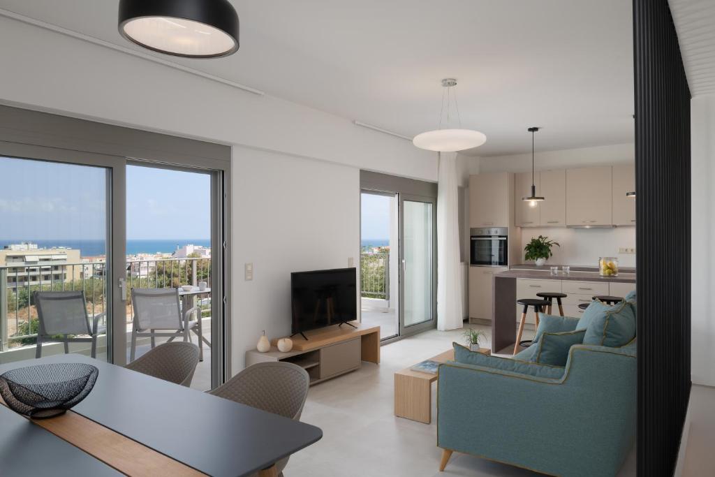 a living room with a couch and a table and a kitchen at Kallithea Residence in Rethymno