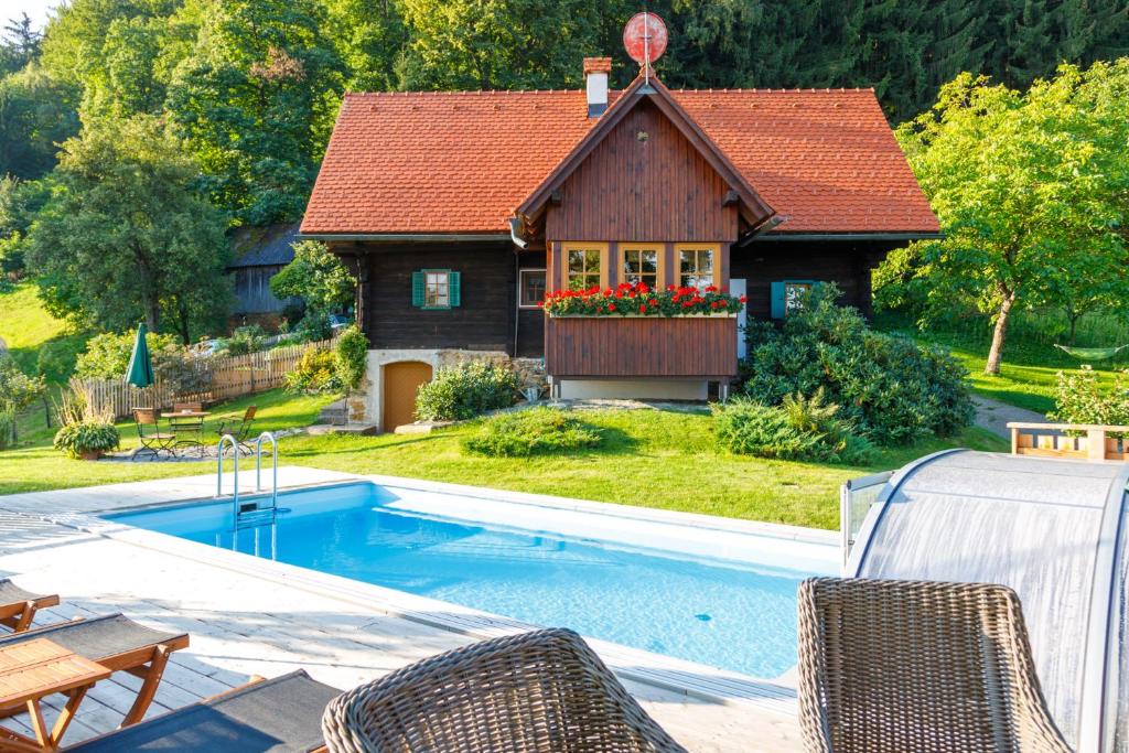 una casa con piscina frente a una casa en Ferienhaus Pilch Hiasl en Oberhaag