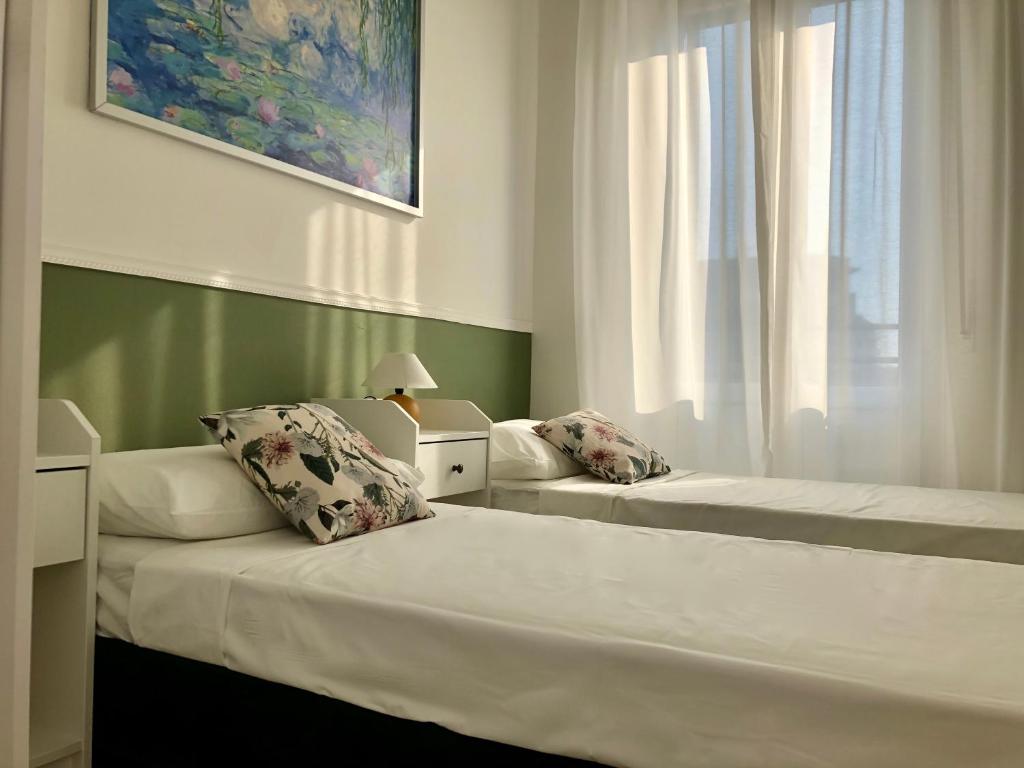 1 dormitorio con 2 camas y ventana en Marco Polo GreenRoom en Milán