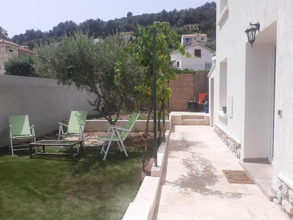 d'une terrasse avec des chaises et un arbre dans une cour. dans l'établissement Almanarre, à Hyères