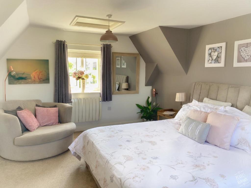 a bedroom with a large bed and a chair at The Loft at Peake’s retreats in Needwood