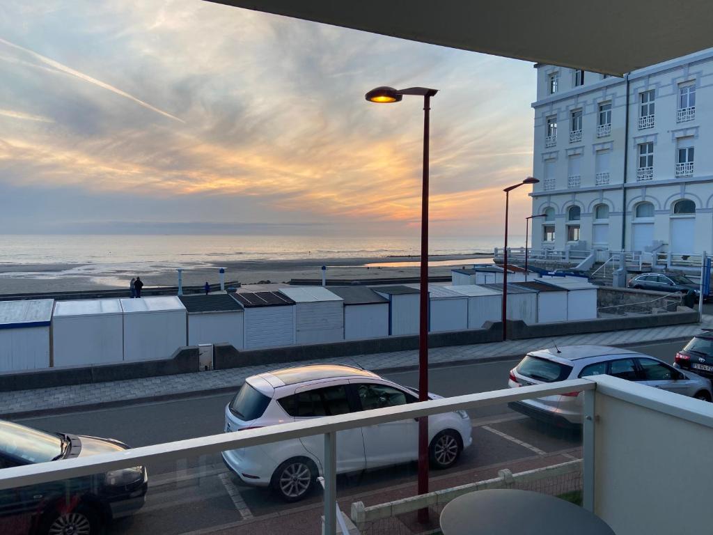un grupo de autos estacionados en un estacionamiento cerca del océano en Front de mer à Wimereux - Wifi-, en Wimereux